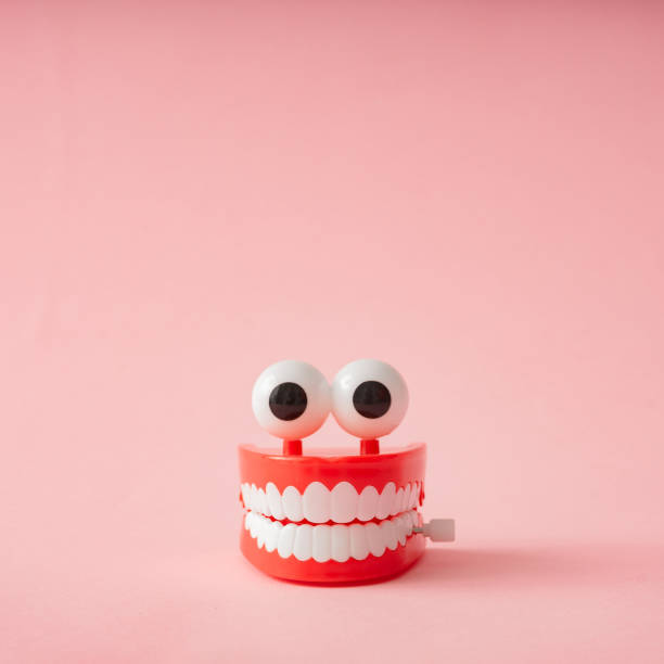 istock Plastic toy teeth against pastel background. 1127971087