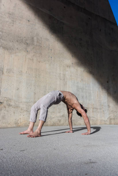 istock Man performing advanced yoga exercises and stretching. 1127971110