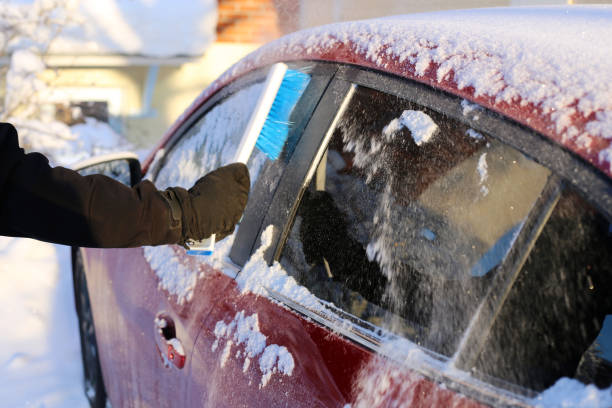 istock Brushing Snow off from the Windows of a Red Car 1127972207