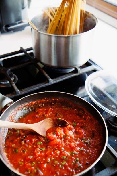 Preparing fresh tomato sauce in a domestic kitchen. stock photo