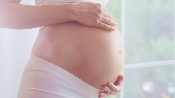 waiting for a baby. pregnant woman rubbing her naked belly - abdomen women loving human hand imagens e fotografias de stock
