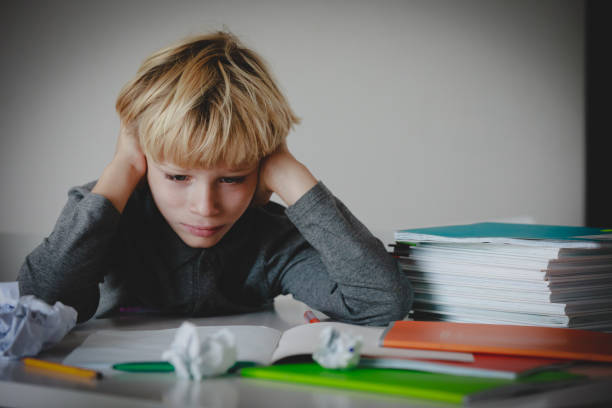 istock little boy tired stressed of doing homework, bored, exhausted 1127974849