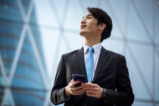 istock Chinese businessman using a smart phone outdoors 1127975156