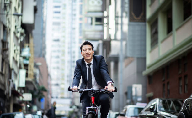 istock Chinese businessman riding to work with his bicycle 1127975202