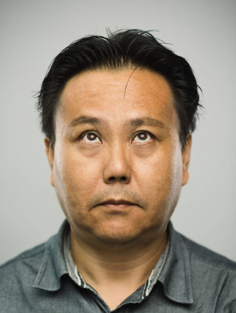 istock Real chinese mature man with blank expression looking up 1127975286