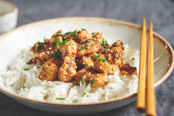 istock Sesame chicken pieces with rice on a ceramic plate. Chinese traditional dish. 1127975524