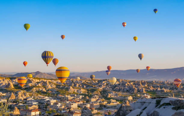 colorful hot air balloons flying over rock landscape at cappadocia turkey - cappadocia hot air balloon turkey basket imagens e fotografias de stock