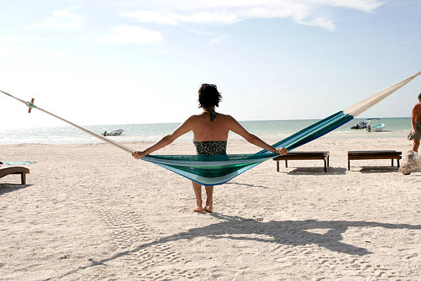 Male senior relaxing while on vacation in Asia, he enjoys the sea, sun and hammock.