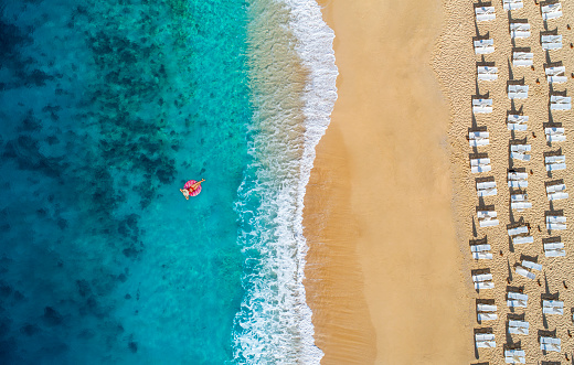 Aerial view of swimming in clear turquoise water with swimming float. Mediterranean sea.