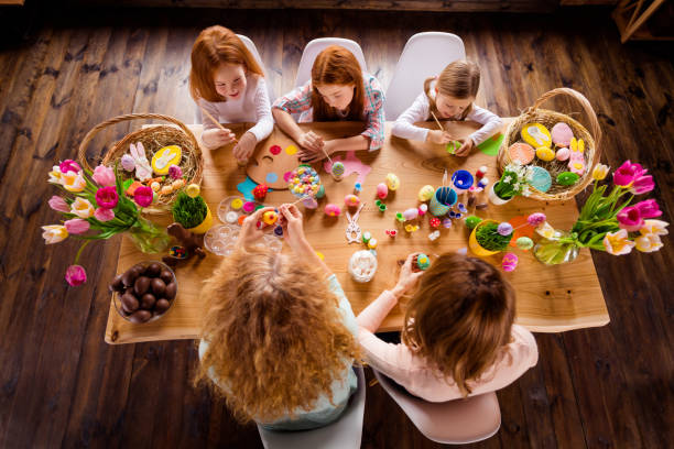 istock Close up top above high angle view photo five children one room making decorating eggs easter symbols weekend children day concept small pretty cute ready celebrate holiday sit big wooden table floor 1127977866