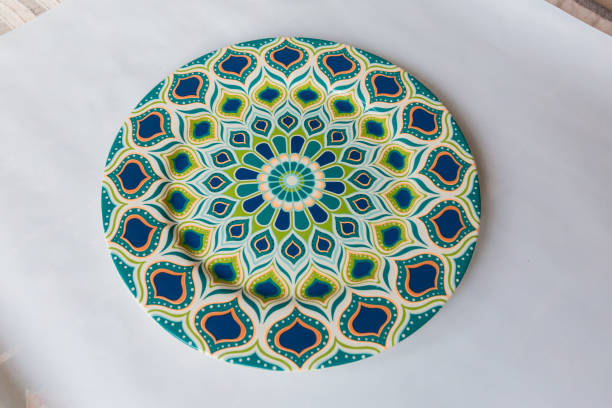 istock a white round plate with floral and line pattern on white background 1127978416