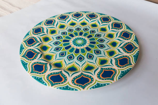 istock a white round plate with floral and line pattern on white background 1127978417