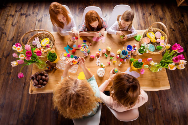 istock Close up top above high angle view photo three children one room making decorating eggs easter symbols weekend children day concept funny pretty cute ready celebrate holiday sit big wooden table floor 1127978509