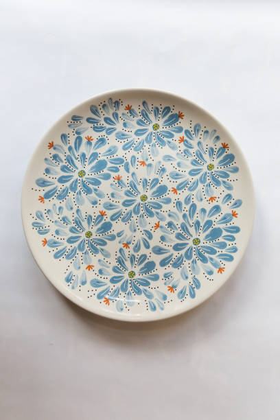 istock a white round plate with floral and line pattern on white background 1127978719