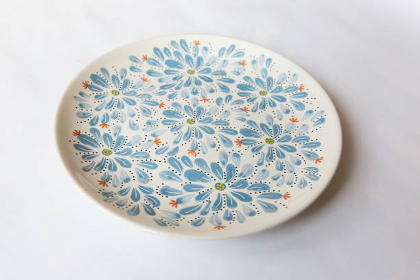 istock a white round plate with floral and line pattern on white background 1127978823
