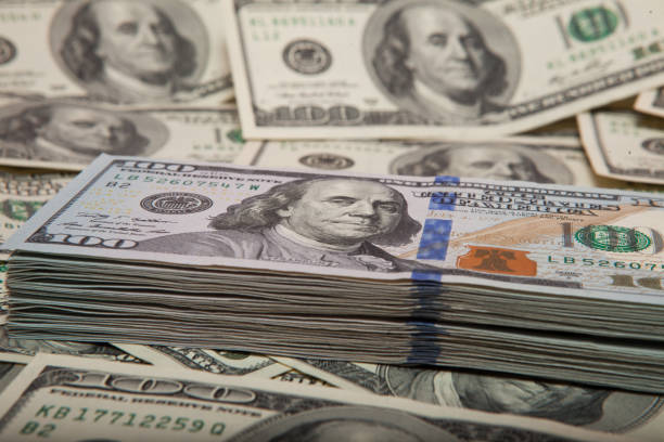 istock stack of dollars against the backdrop of money 1127979562