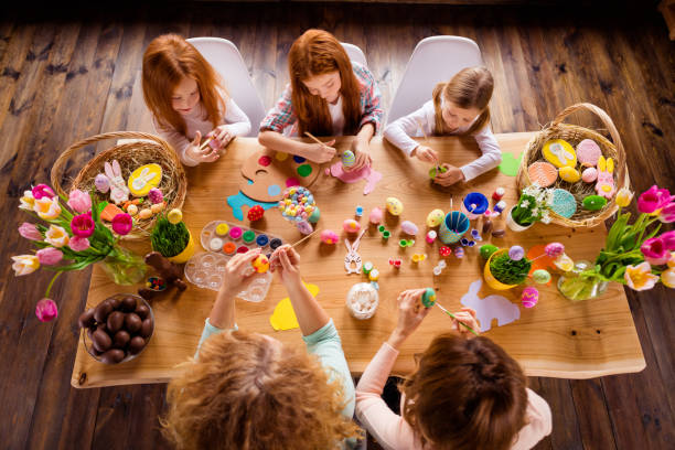 istock Close up top above high angle view photo group five family making decorating eggs easter symbols weekend children day concept funny pretty cute ready celebrate holiday sit big wooden table floor 1127980018