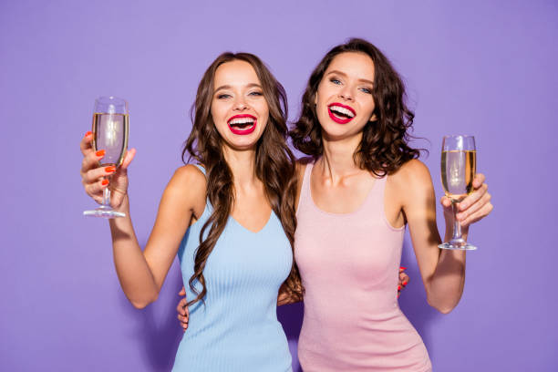 close up portrait two stunning curly wavy she her lady say toast for bride lipstick white teeth arms hands hold golden beverage wear festive dresses isolated purple violet vivid vibrant background - bachelorette party imagens e fotografias de stock