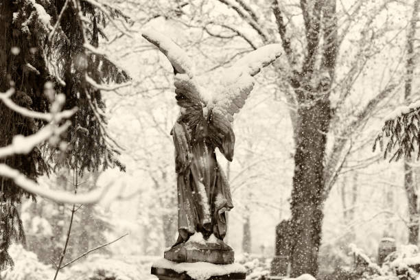 istock Antique Angel Statue on a Graveyard in deep Snow 1127981138