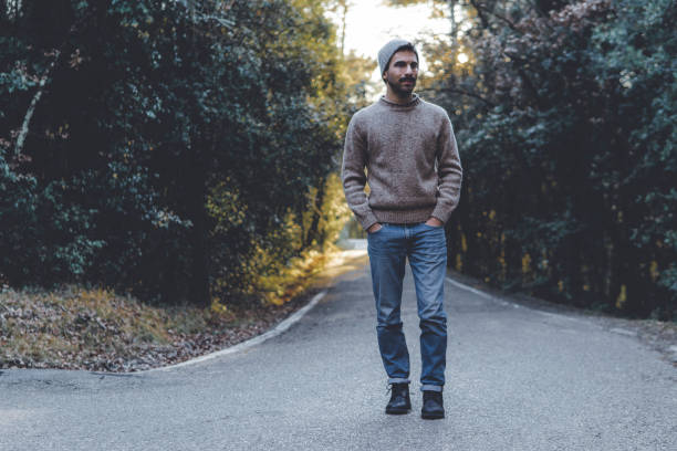 istock Man walking along a street inside a forest 1127981263