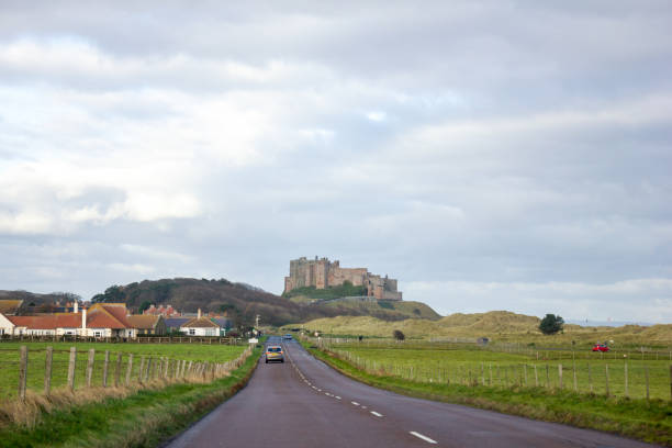 route vers bamburgh - bamburgh castle bamburgh road castle photos et images de collection