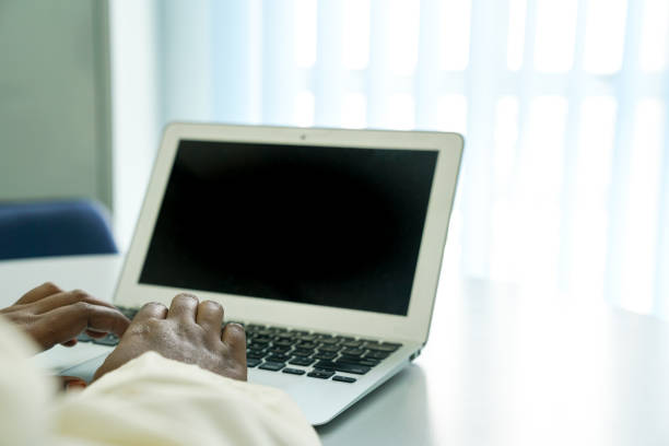 Hands on the keyboard of a notebook on a desk