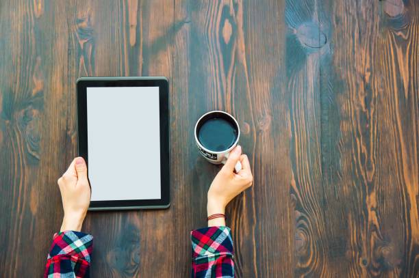 istock Hands holding a tablet and a cup of coffee 1127983573