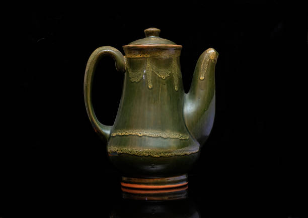 istock clay teapot on black background 1127984250