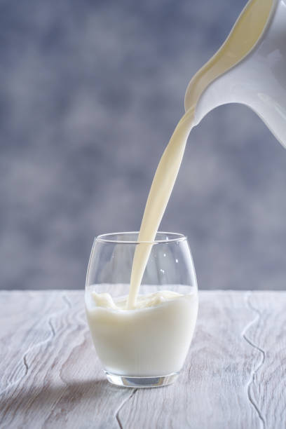 istock Pouring fresh milk into glass close up. 1127986353