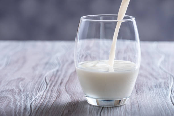 istock Pouring fresh milk into glass close up. 1127986362