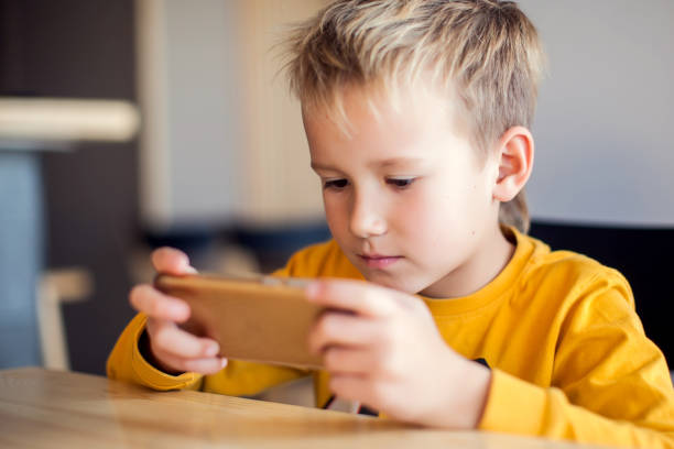 istock Children, technology and internet concept. Little smiling boy playing games on digital smartphone 1127993250
