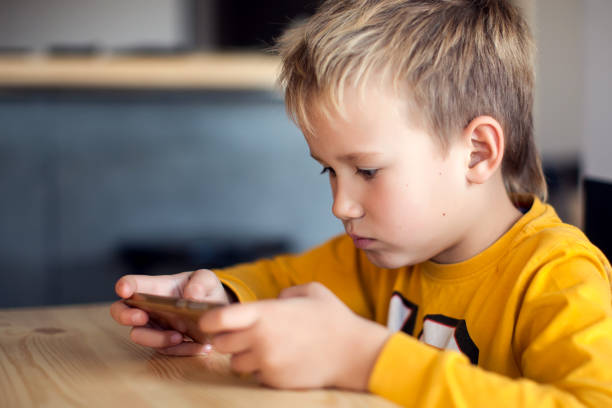 istock Children, technology and internet concept. Little smiling boy playing games on digital smartphone 1127993260