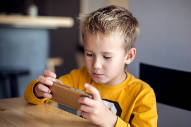 istock Children, technology and internet concept. Little smiling boy playing games on digital smartphone 1127993264