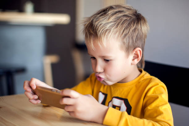 istock Children, technology and internet concept. Little smiling boy playing games on digital smartphone 1127993265