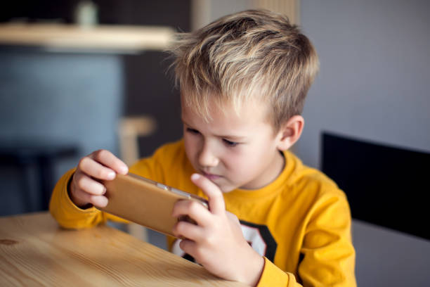 istock Children, technology and internet concept. Little smiling boy playing games on digital smartphone 1127993267