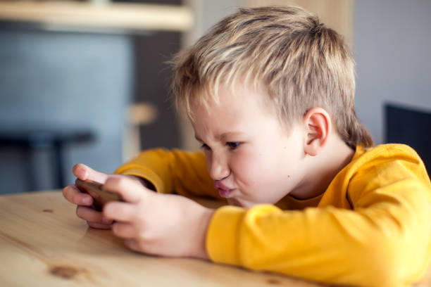 istock Children, technology and internet concept. Little smiling boy playing games on digital smartphone 1127993276