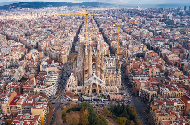 Barcelona; aerial view of Temple Expiatori de la Sagrada Familia Aerial; drone view of main Gaudi project Sagrada Familia Temple; majestic building towering over the rooftops of Eixample district; long construction of the temple "business card" of Barcelona, Spain barcelona skyline stock pictures, royalty-free photos & images