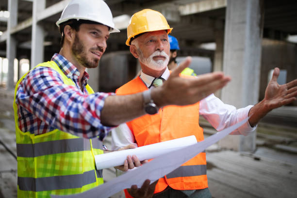 istock Team of architects and engineer in group on construciton site check documents and business workflow 1127995519