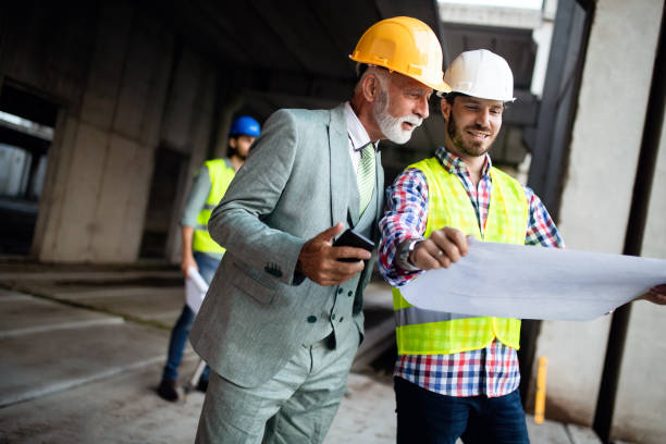 istock Confident team of architects and engineers working together on construction site 1127995606