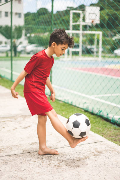 istock Boy playing soccer in the court 1127997704