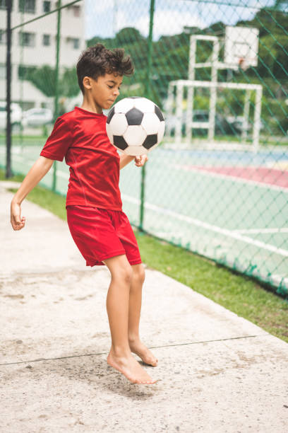 istock Child playing football 1127997788