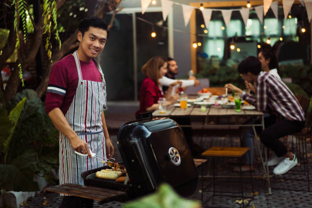 asian man are cooking for a group of friends to eat barbecue - party beach indian ethnicity adult imagens e fotografias de stock