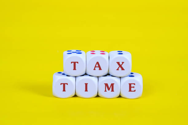 istock Tax time text on dice with yellow background. 1127998306