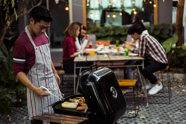 asian man are cooking for a group of friends to eat barbecue - party beach indian ethnicity adult imagens e fotografias de stock