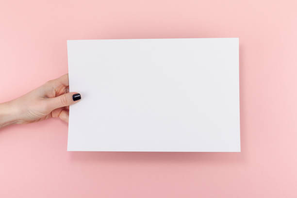 istock Woman hands with blank A4 paper sheet mockup 1127999654