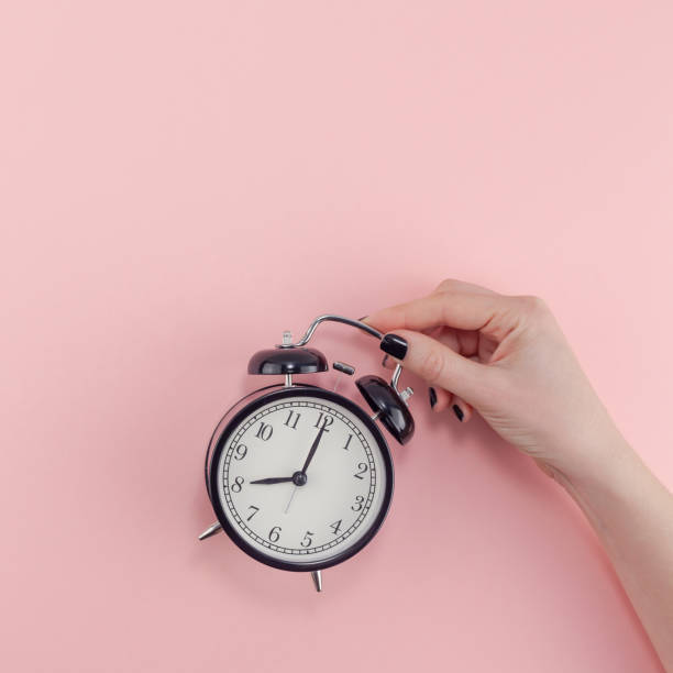 istock Female hand with alarm clock. Morning concept 1128000503