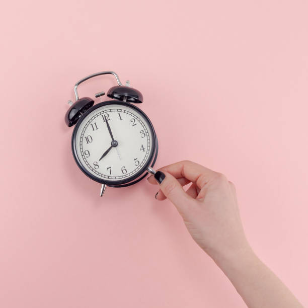 istock Female hand with alarm clock. Morning concept 1128000529