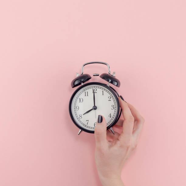 istock Female hand with alarm clock. Morning concept 1128000663