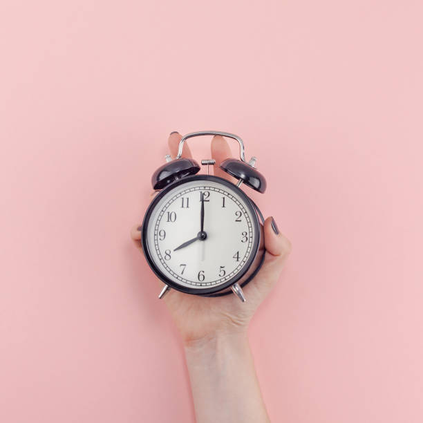 istock Female hand with alarm clock. Morning concept 1128000786
