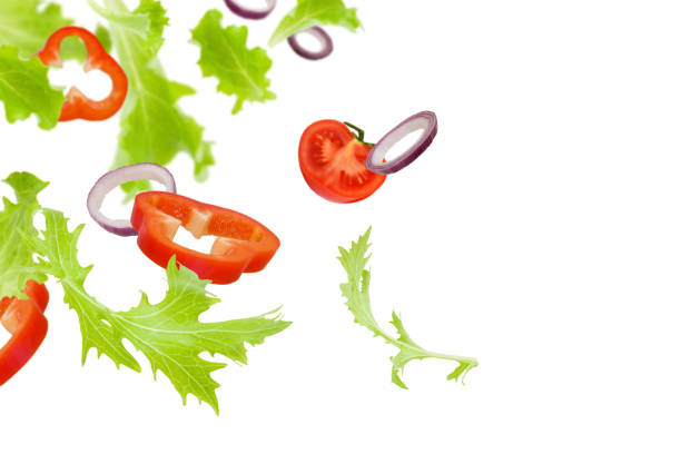 istock Vegetable slices isolated on white background. Flying lettuce, tomatoes, and bell peppers (salad ingredients) isolated on white background 1128001427